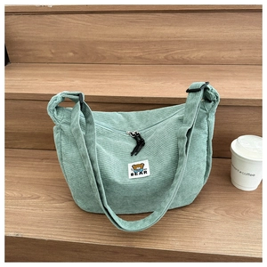 Detail of mint green corduroy bag showing fine texture and cute cartoon bear fabric patch