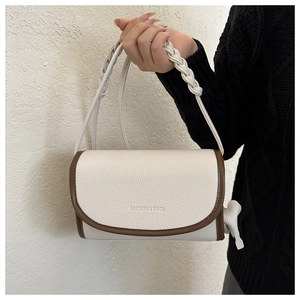 Close-up of contrast crossbody bag with litchi grain texture and side bow detail