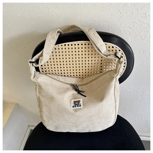 Close-up of beige corduroy crossbody bag featuring a cute bear patch and zipper detail