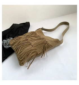 Close-up of bohemian khaki suede shoulder bag featuring long fringe and wide strap details
