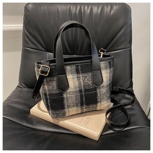 Dettaglio della borsa a tracolla in tweed bianco e nero con manici in ecopelle