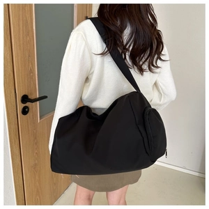 Bolso bandolera minimalista de nailon negro con correa ajustable y detalle de cremallera