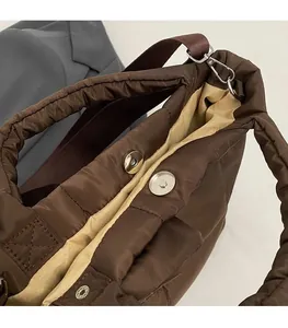 Détail d'un sac cabas matelassé montrant le fermoir magnétique et la doublure kaki
