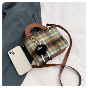 Top view of mini plaid wool handbag with plush coal ball pendant and brown straps