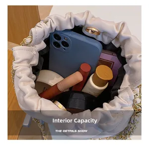 Internal capacity of beige quilted bucket bag showing phone and cosmetics storage