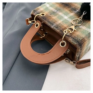 Detailed top view of plaid wool handbag with brown PU leather handle and fur ball charm