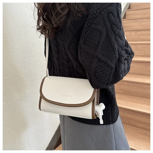 Detail of cream crossbody bag with brown edges and FASHION & BAGS logo embossing