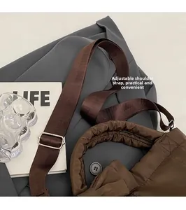 Gros plan du sac matelassé marron montrant sa bandoulière réglable et sa boucle