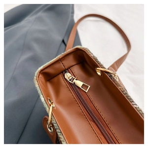 Detail of vintage wool checkered crossbody bag with brown leather and gold zipper