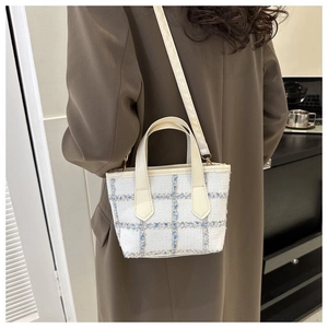 Dettaglio mini borsa a tracolla in tweed a quadretti con manici in pelle morbida