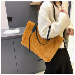 Détail d'un sac cabas en fausse fourrure caramel avec des anses en cuir noir