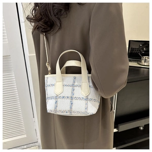 Dettaglio della mini borsa a tracolla in tweed a scacchi con manico in pelle color crema