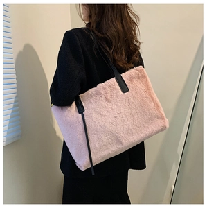 Close-up of pink faux fur tote bag with black straps worn with a stylish winter coat