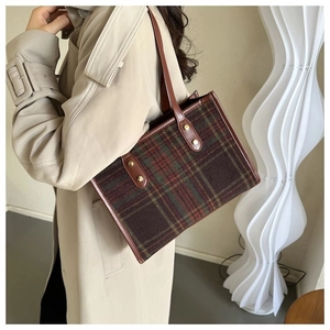 Detailed view of the vintage plaid tote bag with brown leather handles and gold rivets