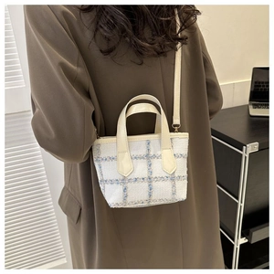 Vista posteriore di una modella con borsa a tracolla in tweed a quadri azzurri e crema