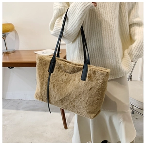 Dettaglio della borsa tote in peluche kaki con sottili spalline in pelle nera sul modello