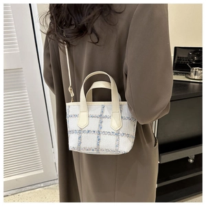 Mini borsa tote in tweed blu e bianco con tracolla in pelle indossata da una modella