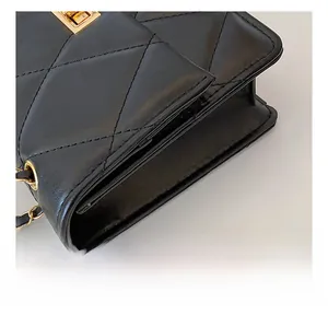 Détail de profil d'un sac à bandoulière matelassé noir avec chaîne dorée et fermoir chic