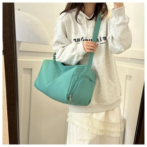 Détail du sac bandoulière en nylon vert menthe montrant le zip latéral et la bandoulière