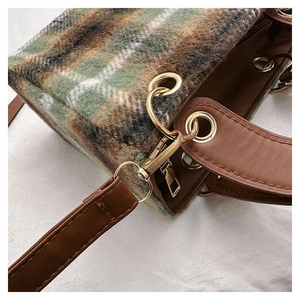 Macro detail of plaid wool texture and premium brown leather trim on the small square bag