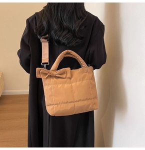 Sac à main matelassé avec nœud et bandoulière réglable porté à l'épaule par un mannequin