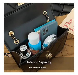 Capacité interne du sac bandoulière en cuir matelassé noir avec maquillage et mobile
