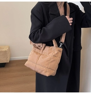 Détail du sac à main matelassé caramel avec un nœud décoratif et une bandoulière en nylon