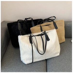 Gros plan détaillé de grands sacs cabas en fausse fourrure noire, beige et blanche