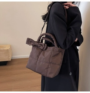 Sac à main matelassé marron avec nœud, porté par un mannequin dans un décor minimaliste