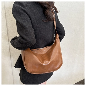 Détail du sac cabas marron vintage brillant avec texture souple et bandoulière réglable