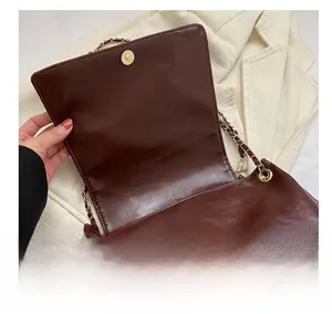 Close-up of a vintage wine red leather bag featuring a high-quality magnetic metal clasp