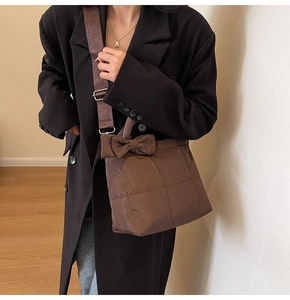 Vue détaillée du sac en nylon matelassé marron avec nœud et texture bouffante