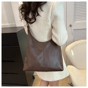Detailed view of deep brown faux leather tote with vertical stitching for autumn outfits