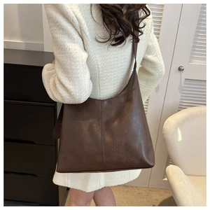 Deep brown matte leather tote bag shown on shoulder for daily commute style