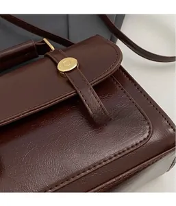 Detail of dark brown vintage faux leather texture and gold magnetic snap closure