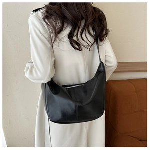 Détail du sac hobo en similicuir noir brillant avec fermeture éclair en métal argenté