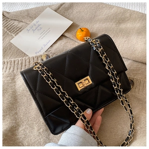 Détail du sac bandoulière en cuir matelassé noir avec chaîne dorée et fermoir pivot