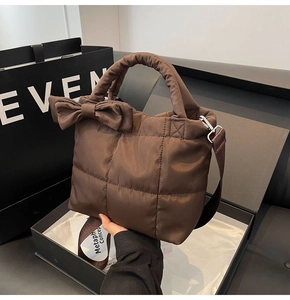 Détail du sac matelassé marron avec grand nœud et large bandoulière en nylon réglable