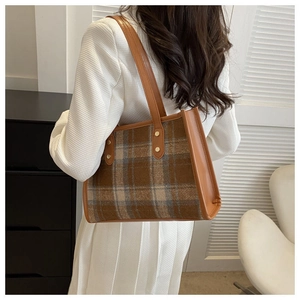 Detail of checkered tote bag featuring vintage brown tweed fabric and leather straps