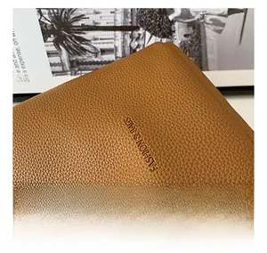 Macro shot of brown pebble grain leather bucket bag featuring debossed fashion branding