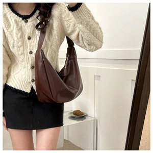 Sac bandoulière minimaliste en cuir mat marron foncé en forme de demi-lune porté