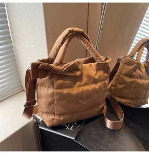 Détail d'un sac à main matelassé marron avec nœud élégant et double bandoulière