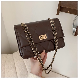 Détail du sac à bandoulière matelassé marron foncé avec fermoir doré et chaîne