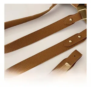 Detail of adjustable brown litchi leather shoulder strap with gold metal buckle