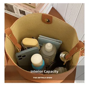 Internal view of large brown bucket bag showing phone, wallet, and cosmetics storage