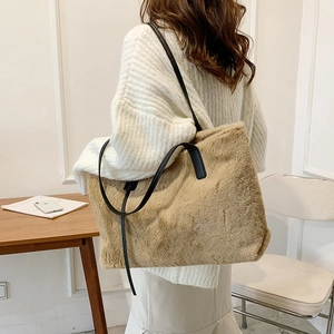 Grand sac cabas en fausse fourrure kaki avec lanières en cuir noir porté par un mannequin