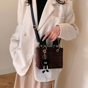 Retro plaid woolen mini square handbag with plush charm shown on a fashion model