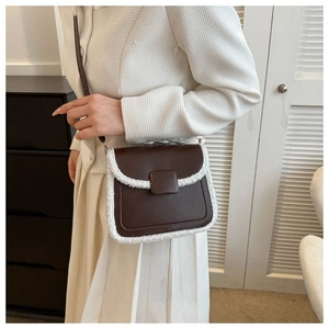 Brown leather crossbody bag with white faux fur trim shown on model with tweed jacket