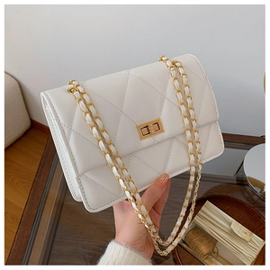 Détail du sac bandoulière matelassé blanc avec fermoir tournant doré et chaîne