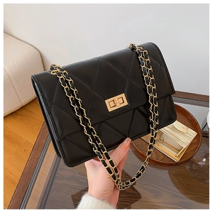 Détail du sac bandoulière matelassé noir avec chaîne dorée et fermoir rotatif en métal